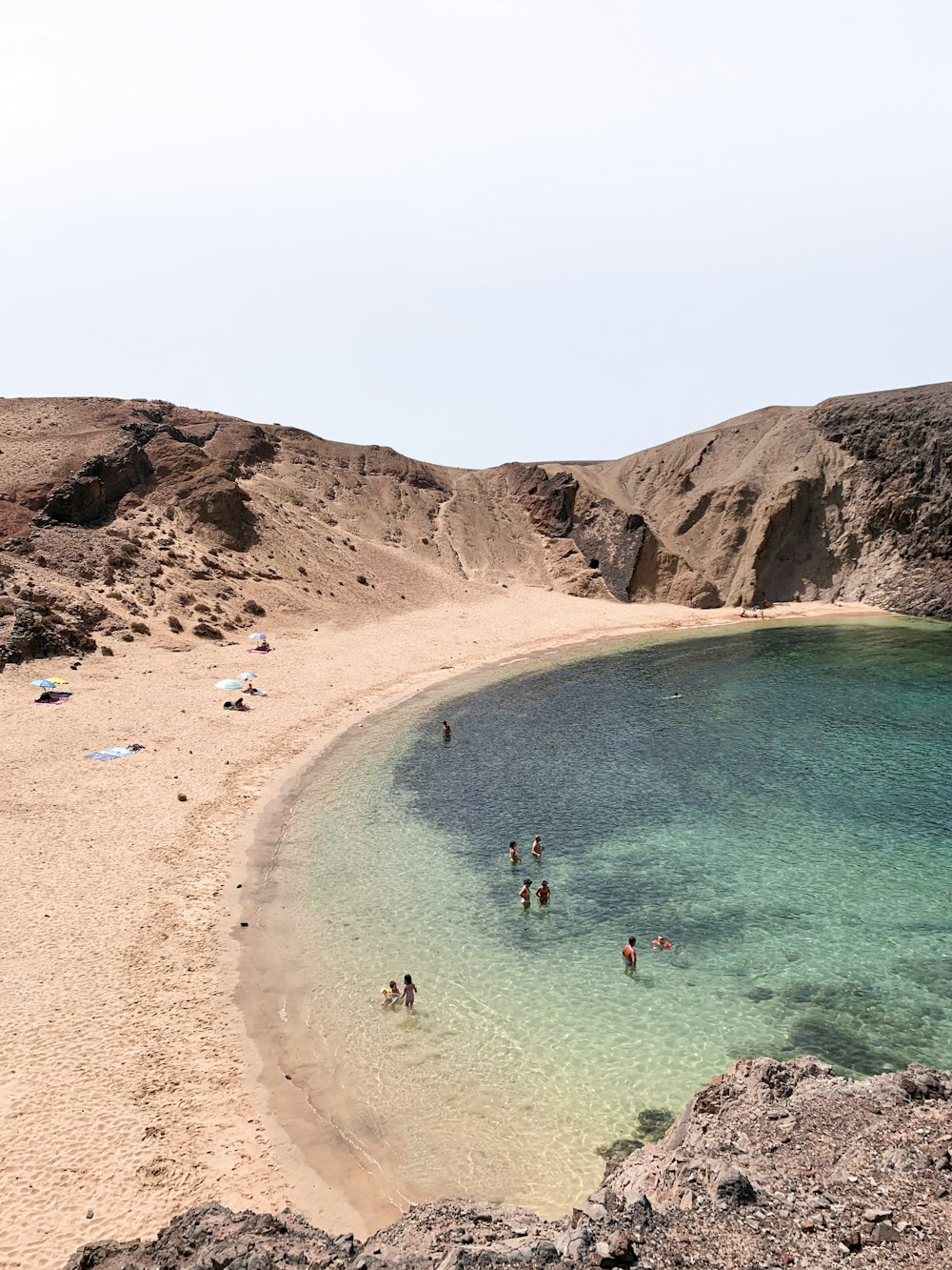 people swimming on beach during daytime