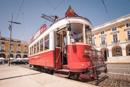 red and white tram on road during daytime in Praça do Comércio Portugal