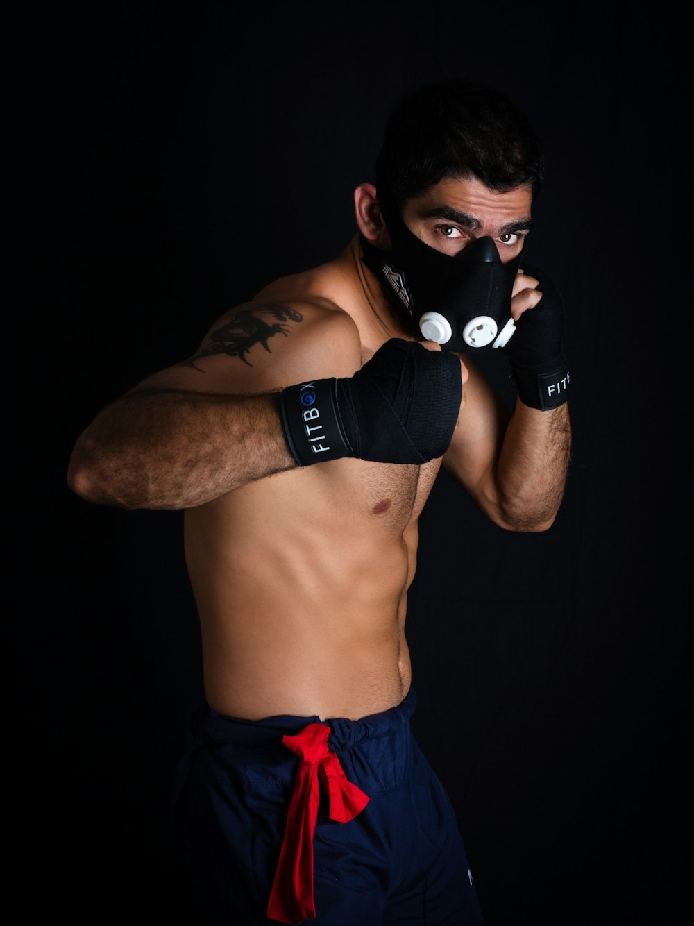 Hombre en topless con guantes de boxeo negros