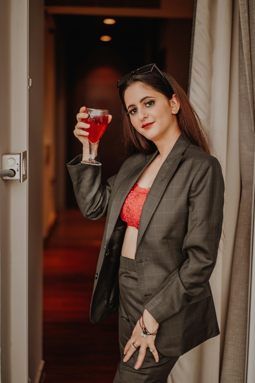 woman in black blazer holding red wine glass