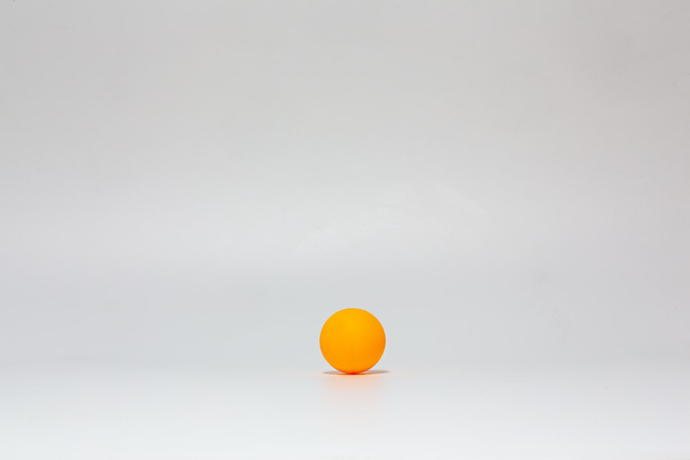bola amarilla sobre superficie blanca