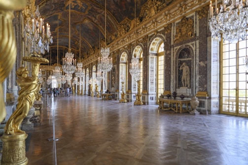 Hall of Mirrors Versailles brown wooden bench near white and gold concrete building