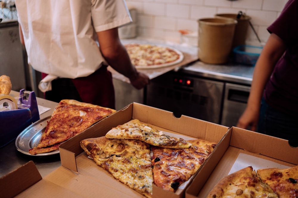 person in white shirt holding pizza