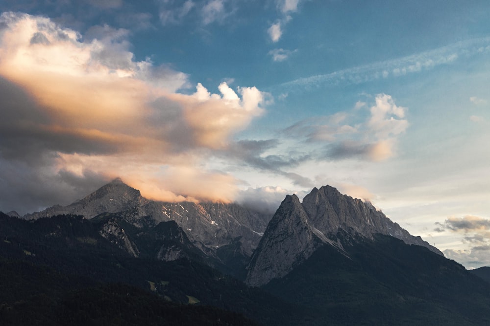 black and white mountains under white clouds and blue sky during daytime