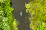A traditional boat taxi navigating through narrow waterways surrounded by lush greenery.