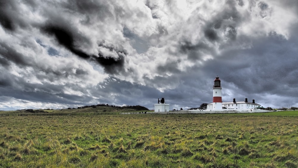 Weißer und roter Leuchtturm unter grauen Wolken