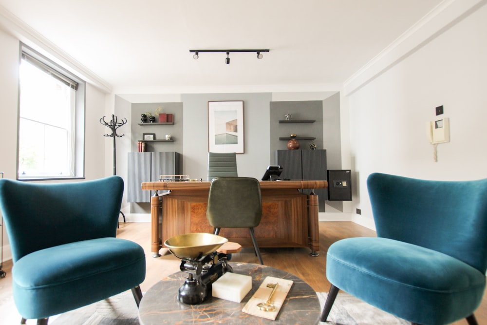 Mesa de madera negra y marrón cerca de silla acolchada azul