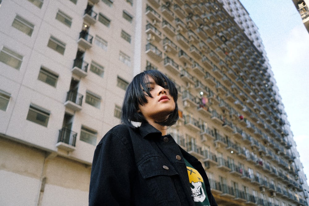 woman in black coat standing near building during daytime