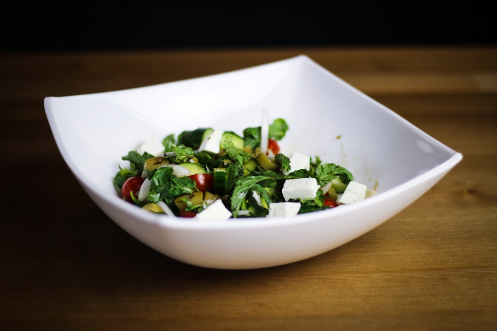 Salade de légumes sur bol en céramique blanche