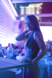 A lively webcam performer engaging with her audience in a cozy, warmly lit room.