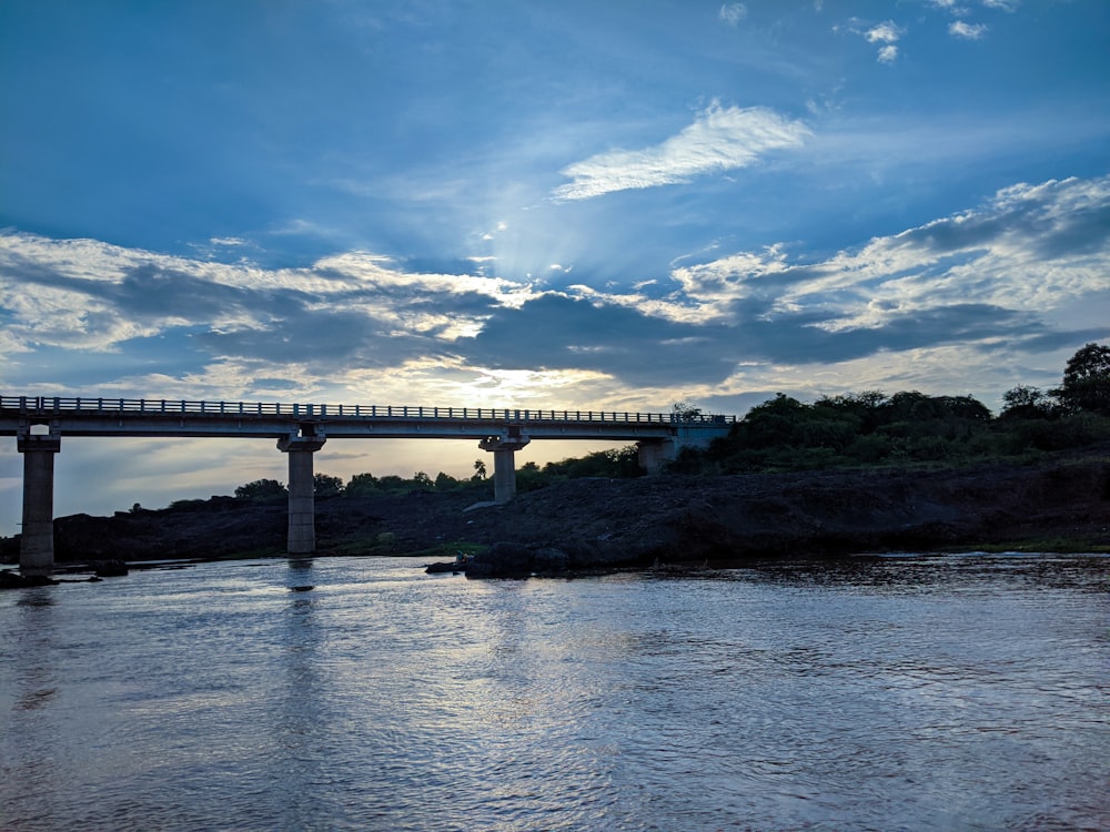 white bridge over river under blue sky and white clouds during daytime