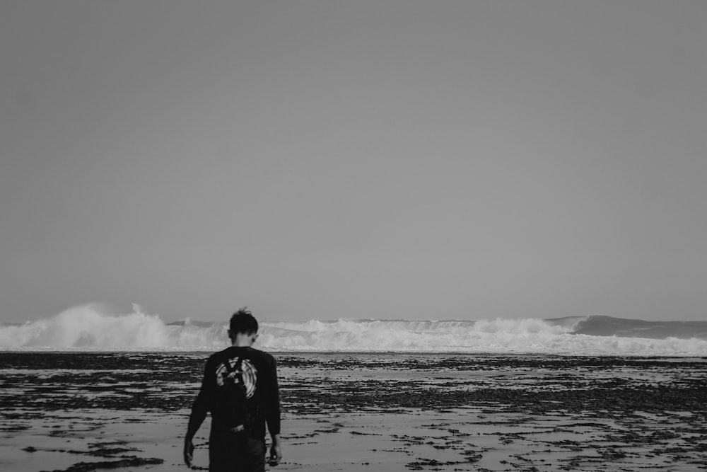man in black shirt standing on seashore