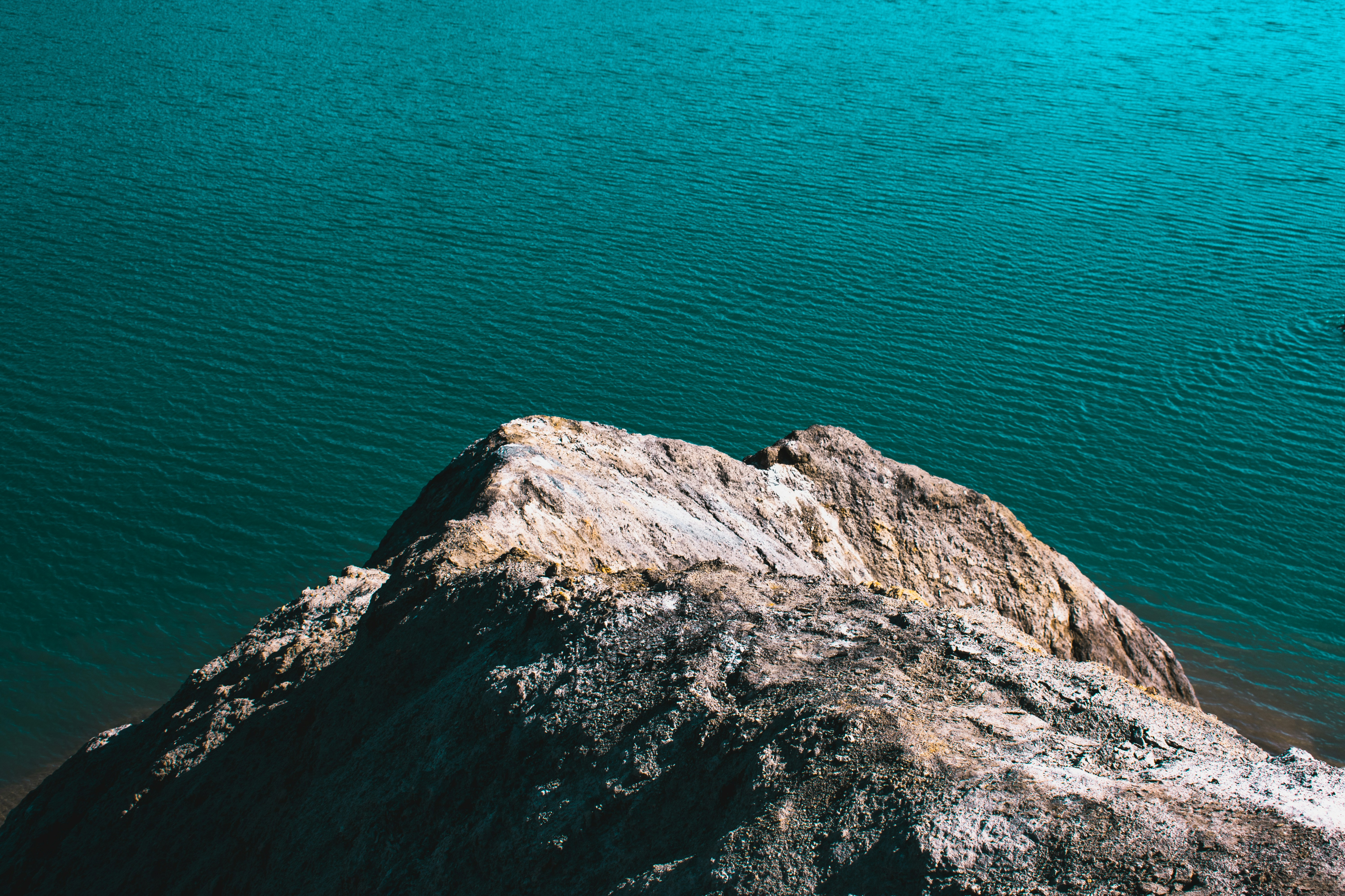 brown rock formation beside blue sea during daytime