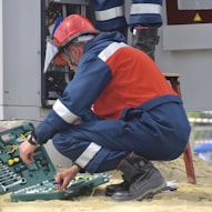 man in red and black jacket wearing black pants and red helmet holding green and black