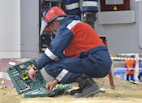 An electrician working carefully on a residential electrical panel with tools.