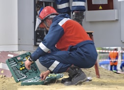 man in red and black jacket wearing black pants and red helmet holding green and black