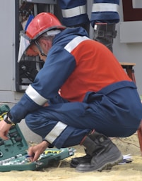 man in red and black jacket wearing black pants and red helmet holding green and black