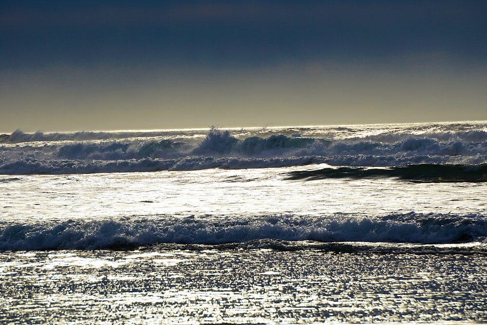 ocean waves crashing on shore during daytime