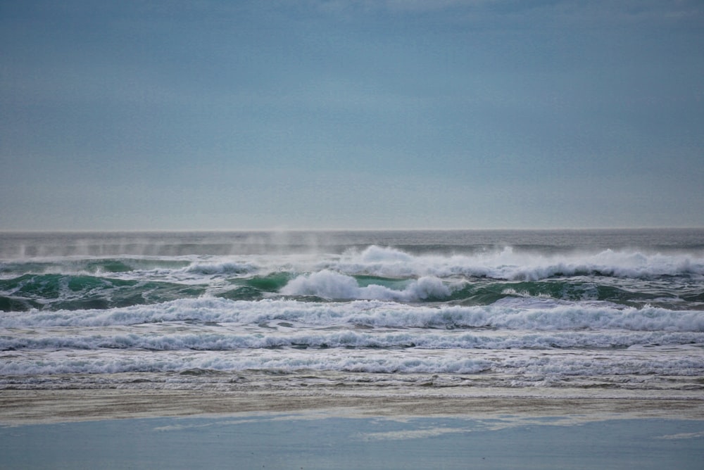 sea waves crashing on shore during daytime