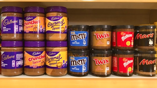 a shelf filled with lots of different types of peanut butter