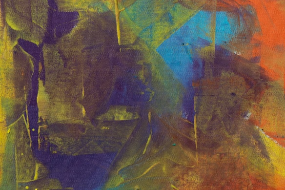 A vibrant abstract painting featuring an interplay of various colors and shapes. Bold strokes of yellow, green, purple, blue, and orange blend into one another, creating dynamic patterns and textures. The canvas shows an expressive use of color and form, suggestive of movement and energy.