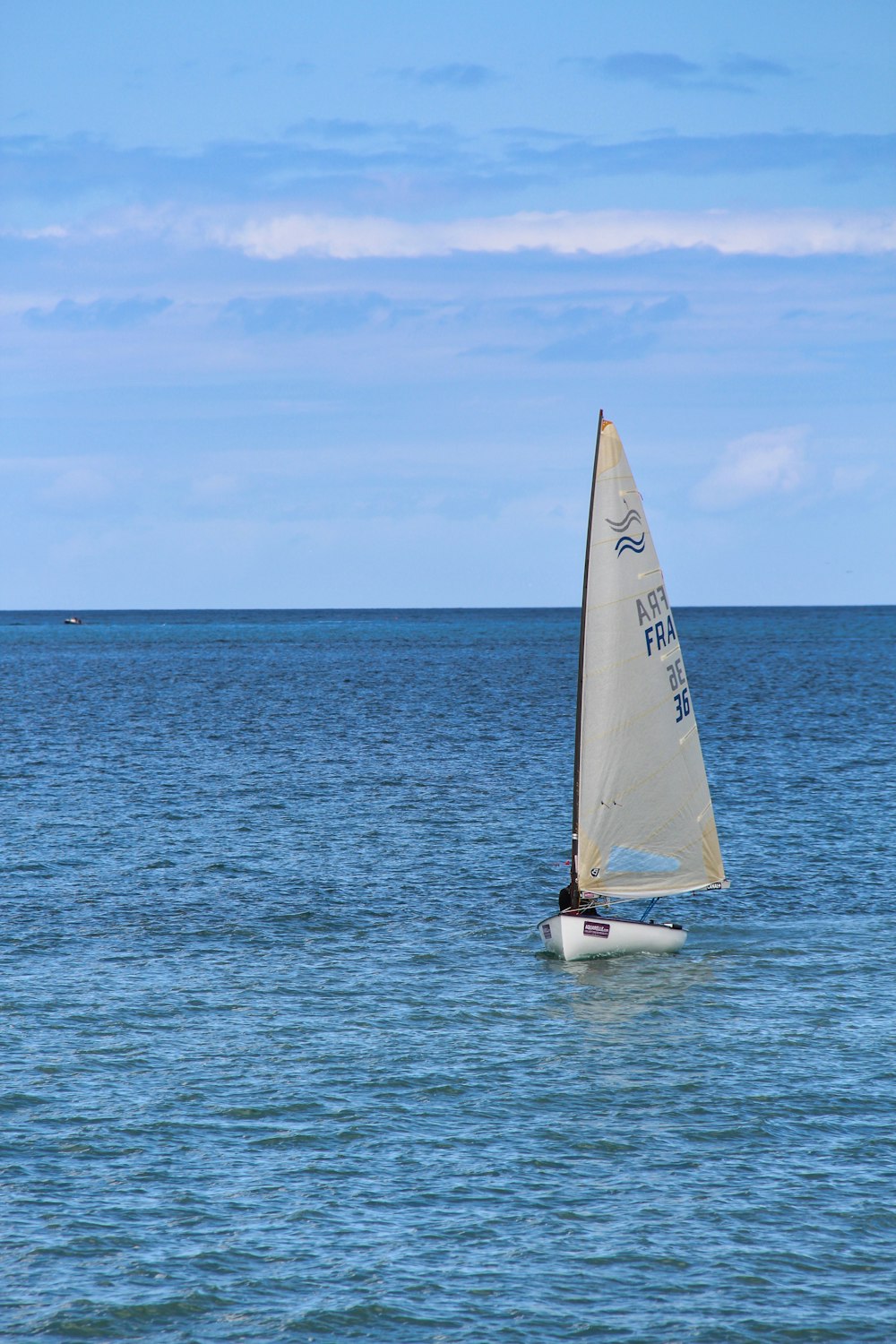 white sailboat on sea under blue sky during daytime