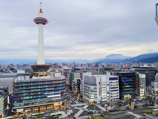 white and red tower in the city during daytime in Kyoto Tower Japan