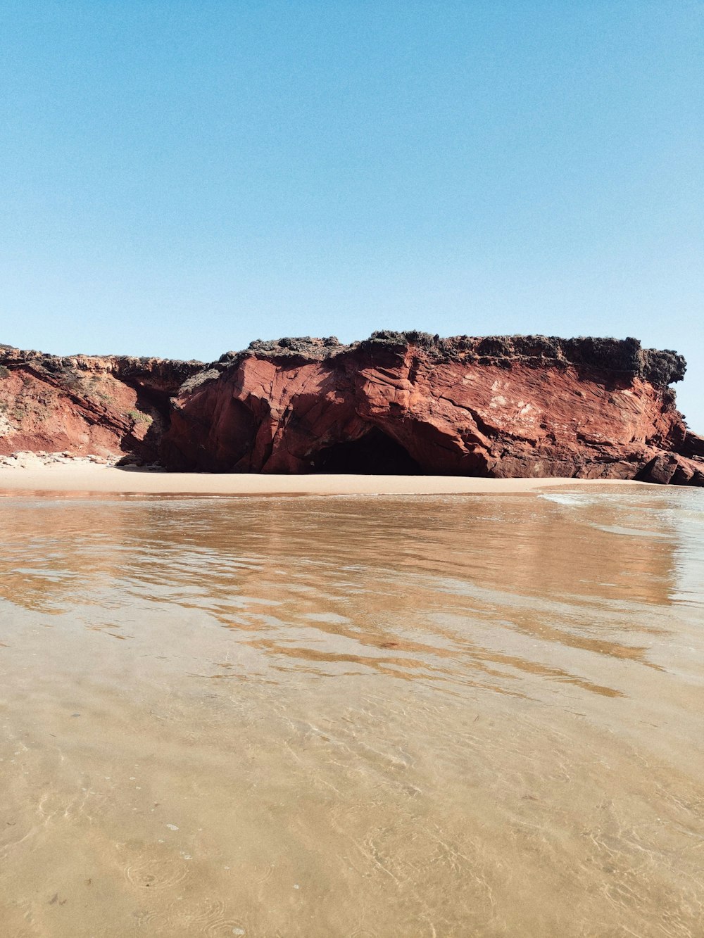 brown rock formation on sea water during daytime