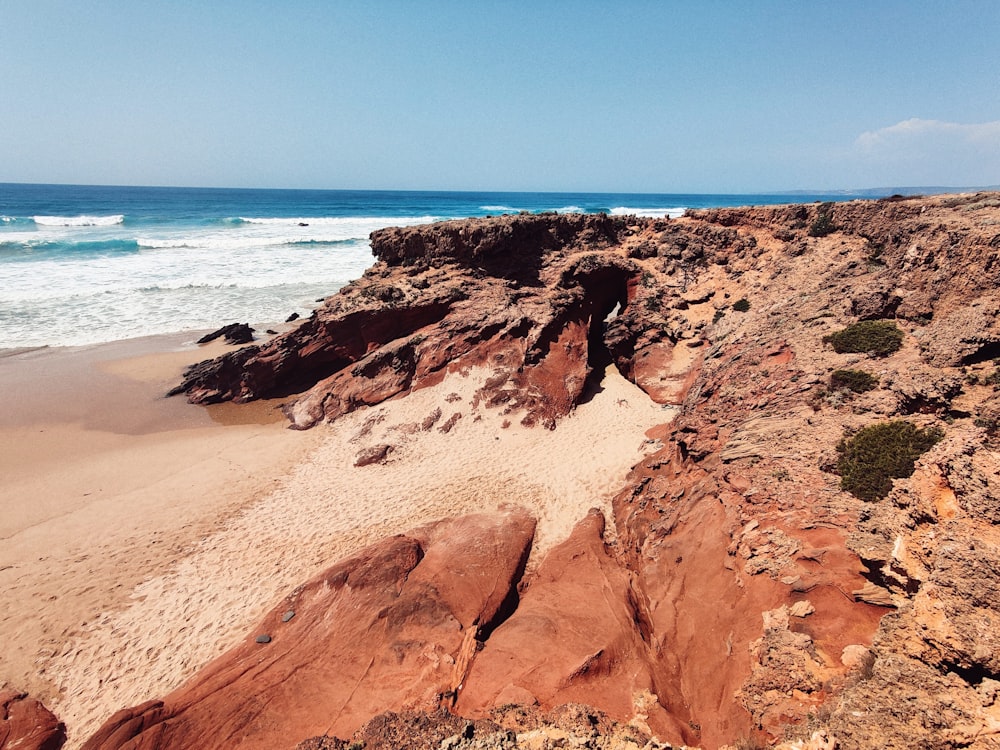 brown rock formation near body of water during daytime