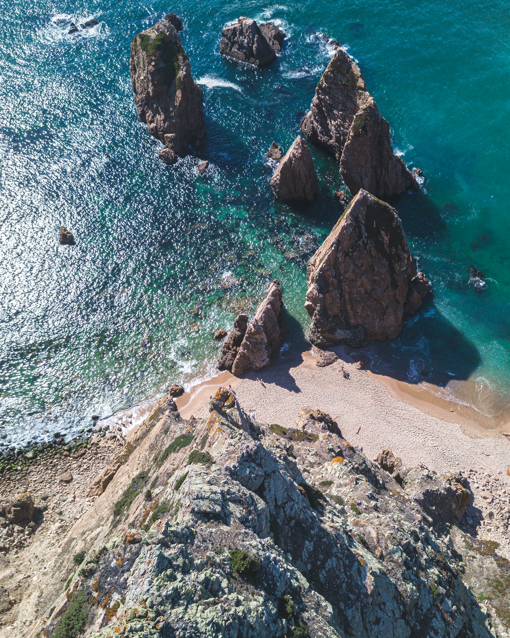 an aerial view of a beach with rocks and water