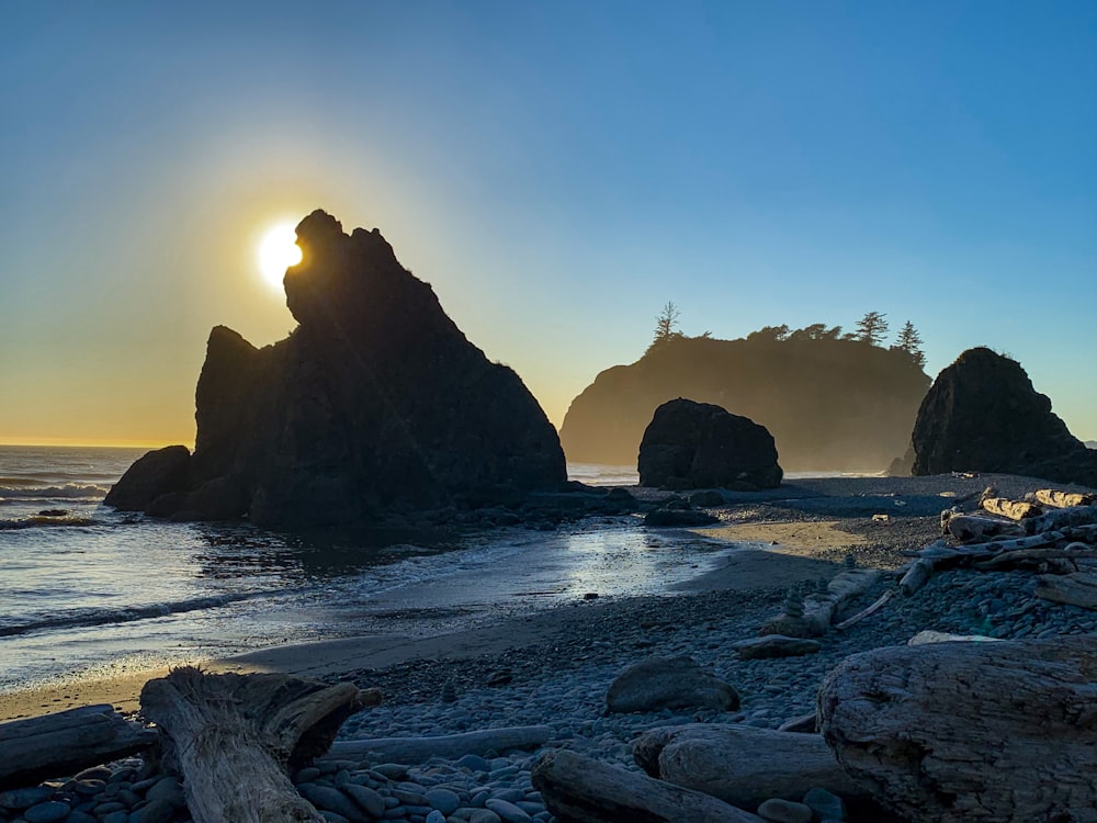 brown rock formation on sea during sunset