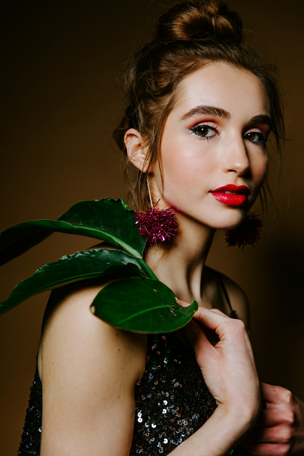 woman holding green leaf with red lipstick