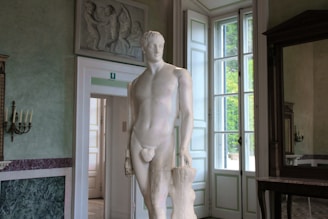 Marble sculpture displayed in a cozy, sunlit studio corner.