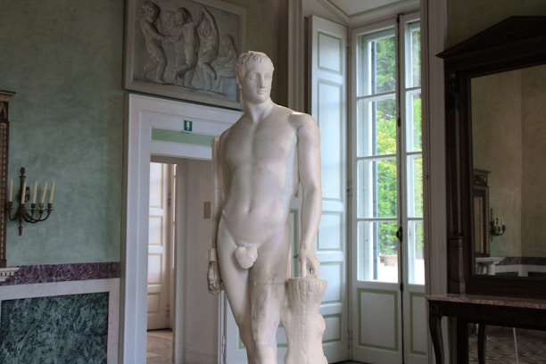 Marble sculpture displayed in a cozy, sunlit studio corner.