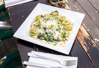 Fresh cheese tortellini nestled in a creamy garlic sauce in a pan