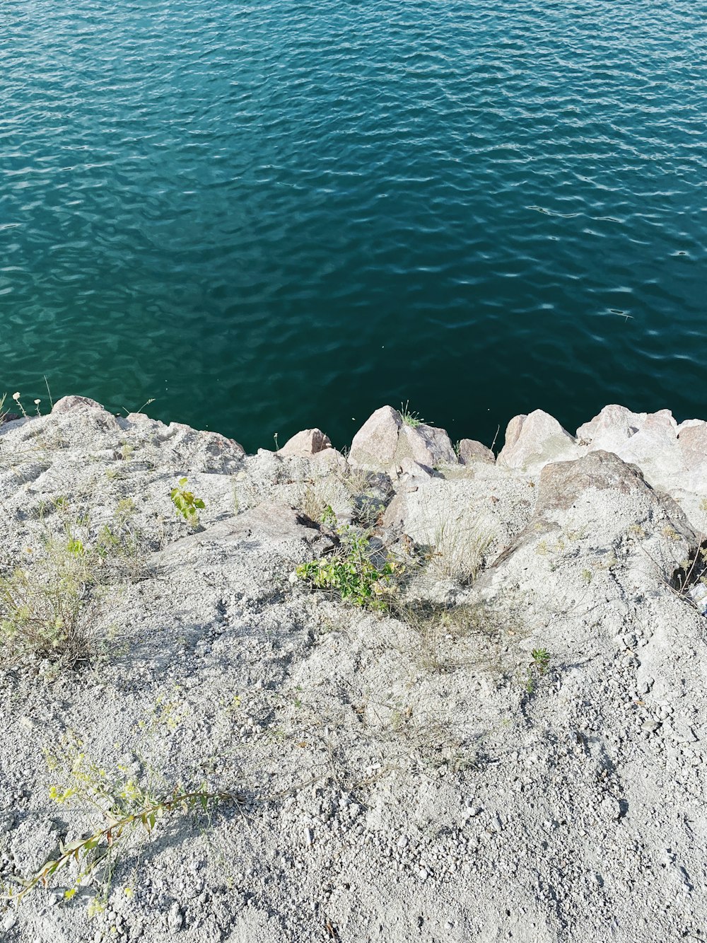 gray rocks beside body of water during daytime
