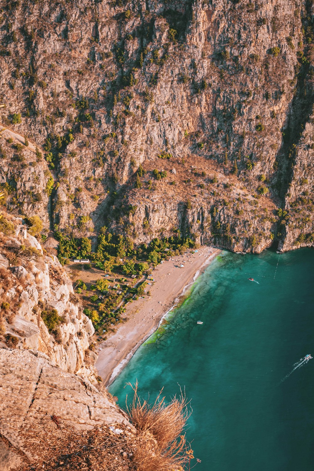 Montaña rocosa marrón junto al cuerpo de agua durante el día