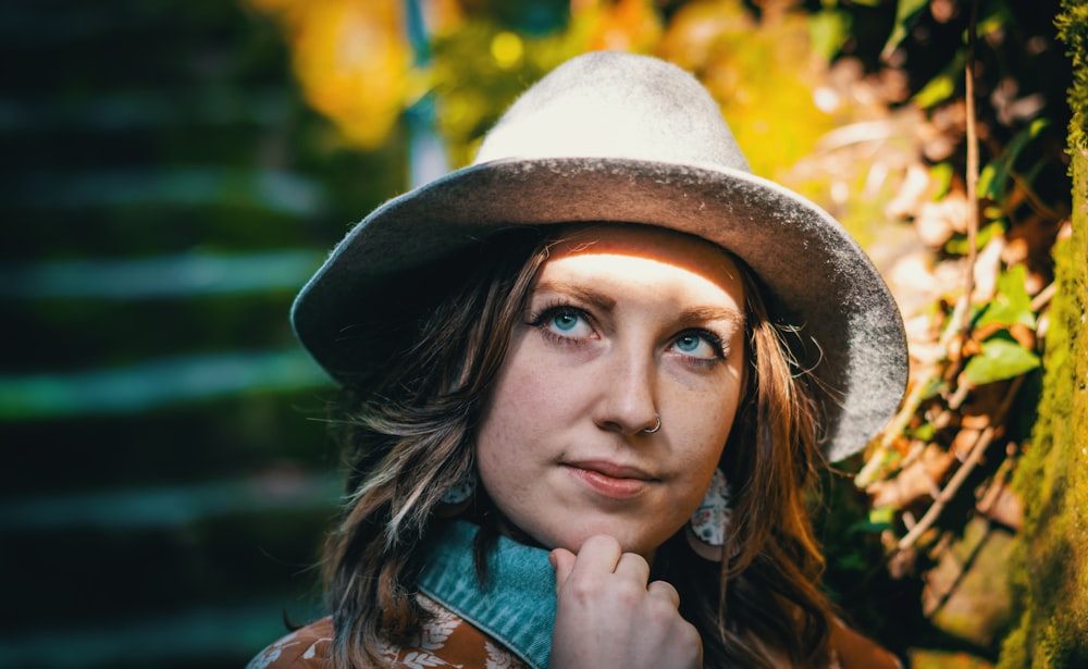 woman in blue denim jacket wearing brown hat