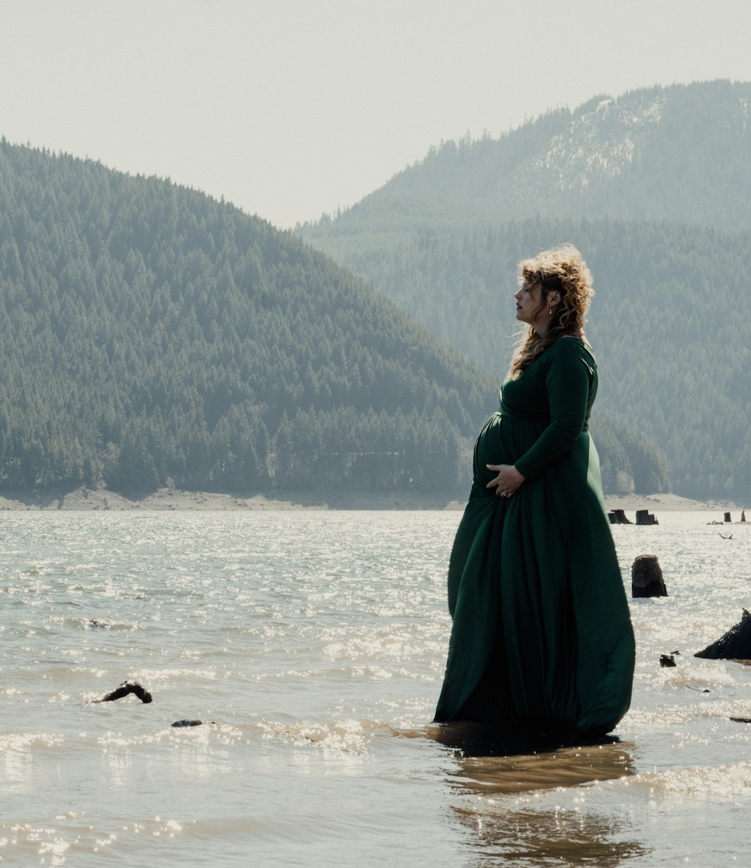 woman in green dress standing on seashore during daytime