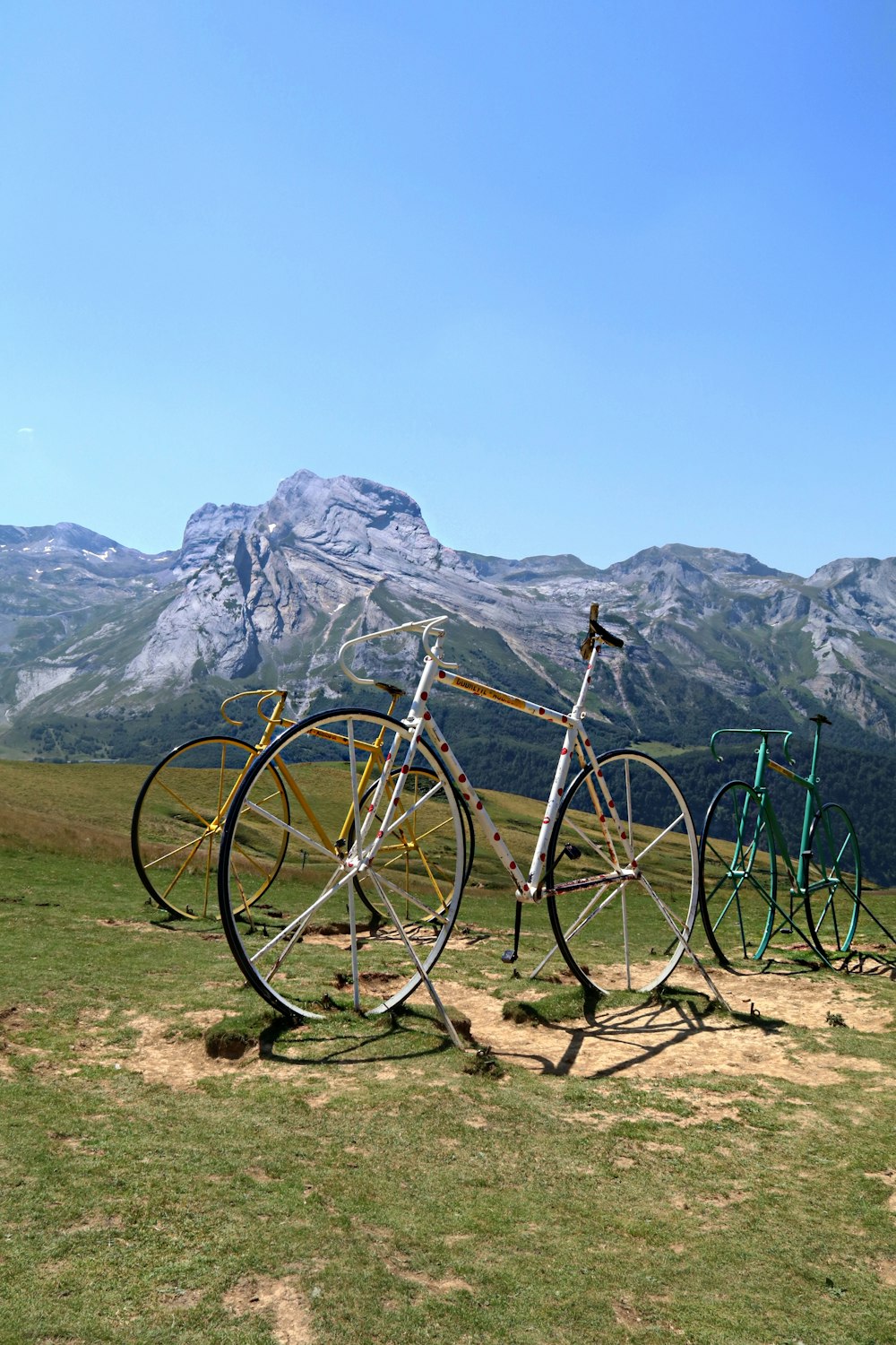 black bicycle on green grass field near mountain during daytime