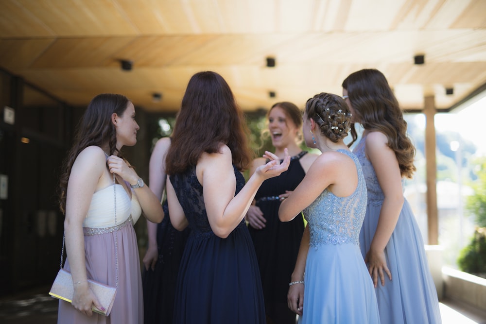 Mujer en vestido negro de pie frente a mujer en vestido blanco