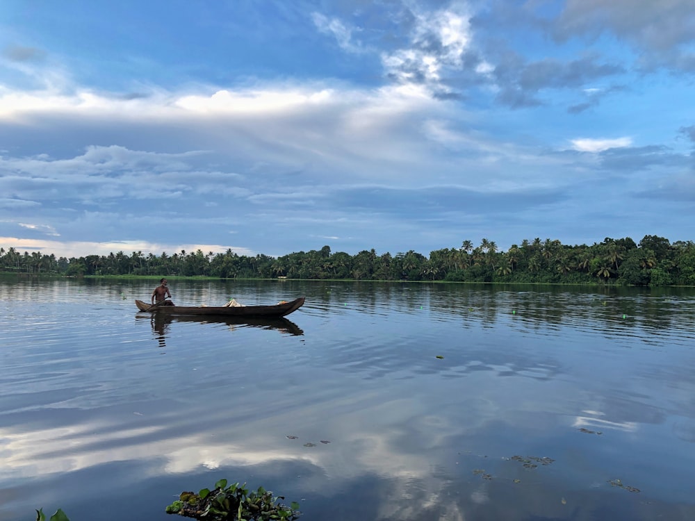 person in boat on water during daytime