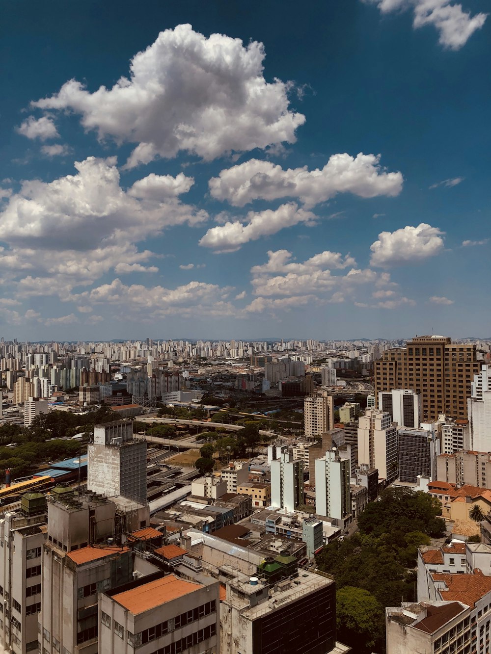 city buildings under blue sky and white clouds during daytime