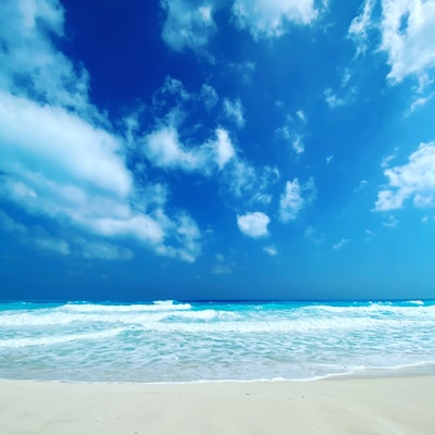 A serene beach scene with gentle waves and a clear blue sky, symbolizing tranquility and wellness.