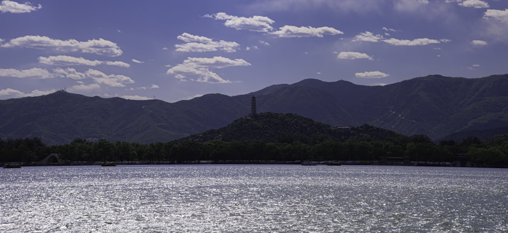 green mountains beside body of water under blue sky during daytime