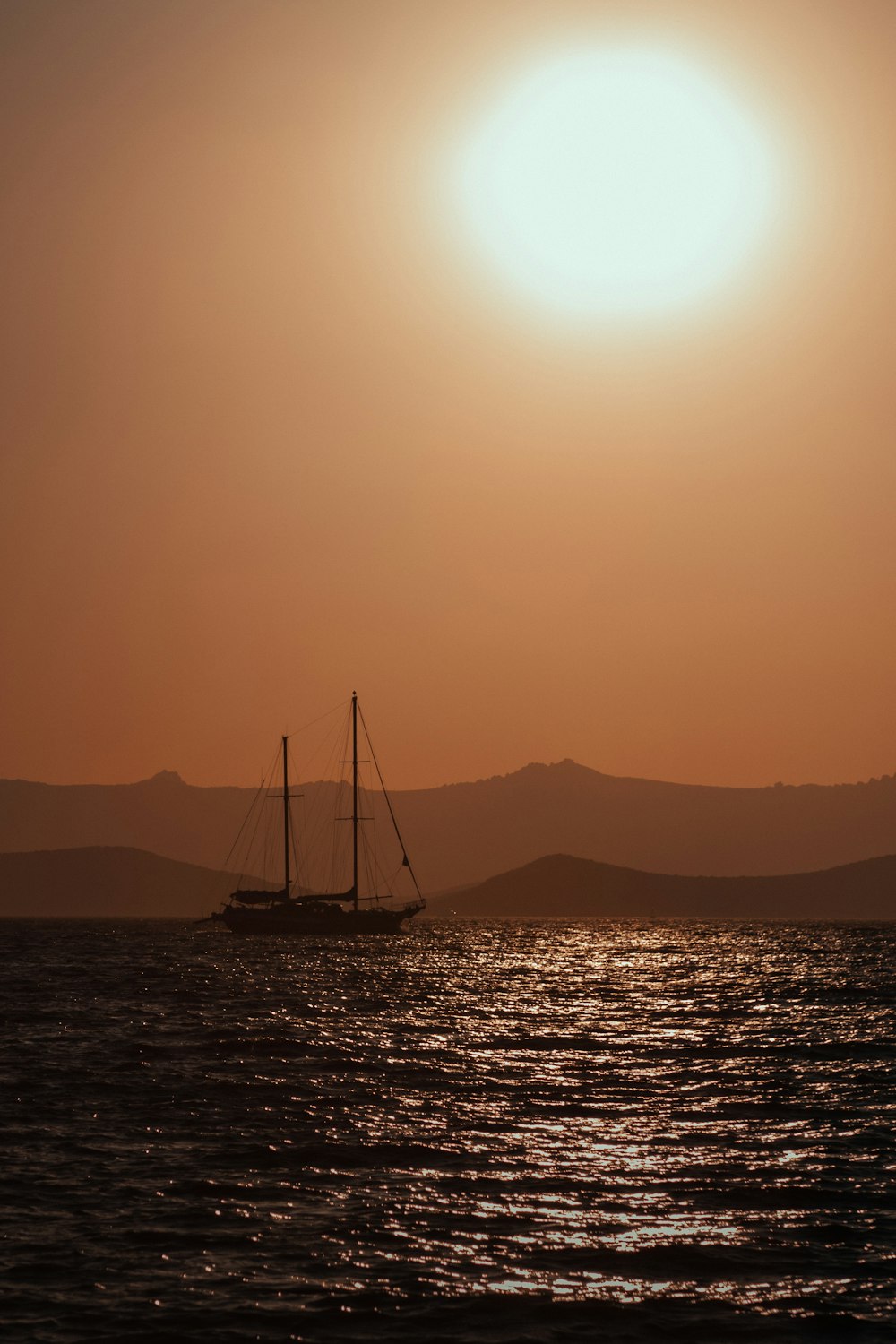 silhouette of sailboat on sea during sunset