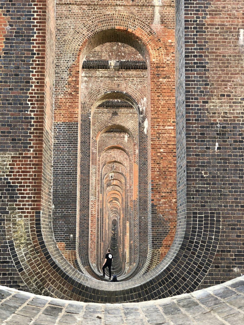 brown brick wall with black metal fence