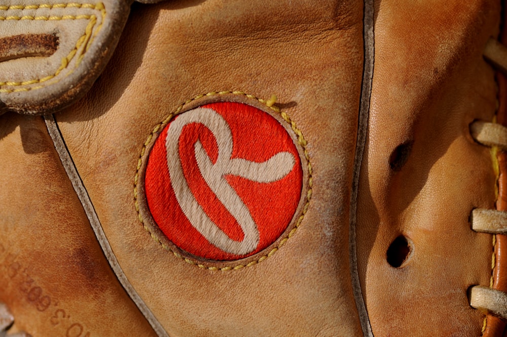 brown leather bag with red logo