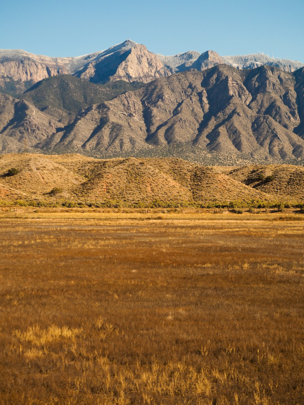 Campo de hierba marrón cerca de la montaña durante el día