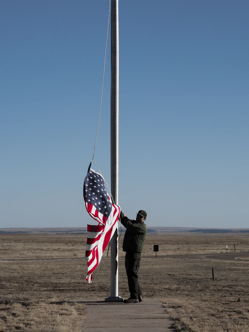 man in black jacket holding us a flag